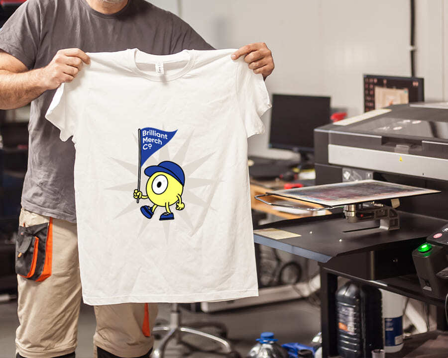 A man holding up a tshirt with a printed design