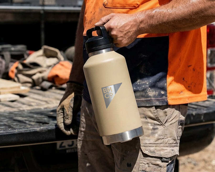 A construction worker holding a fridgy 1.9L all-dayer bottle