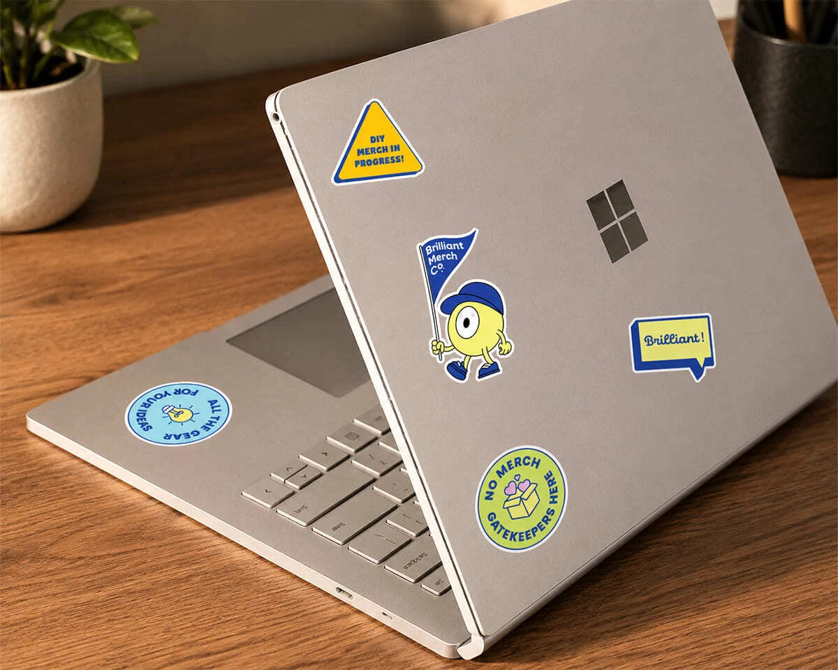 A Windows laptop with custom Brilliant Merch Co stickers