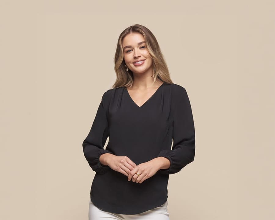 A woman wearing a black cali v-neck popover