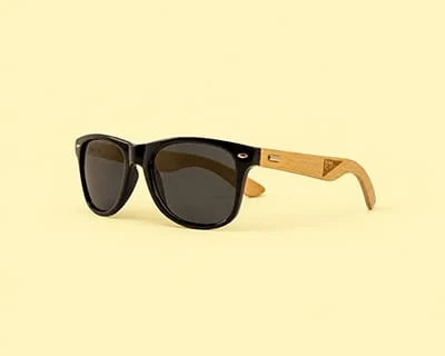 A pair of bamboo sunglasses with laser engraved Brilliant Merch Co logo