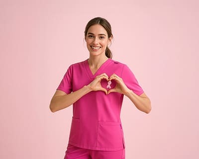 A woman wearing a pink v-neck scrub top