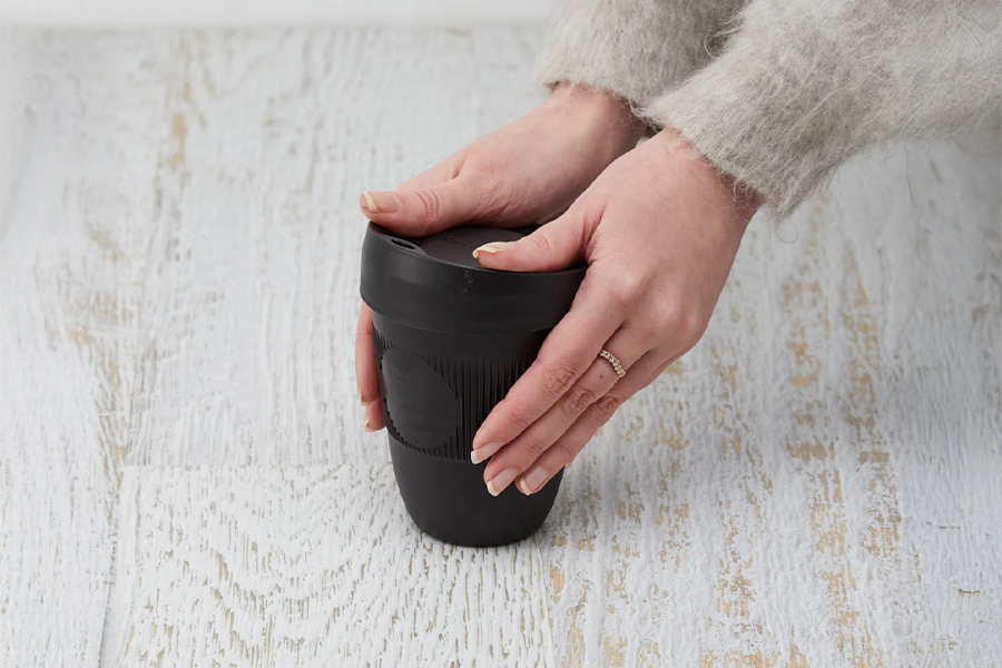 Close-up of a woman holding a grounded goods activation cup