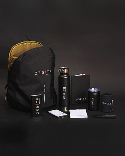 Black backpack, alongside a matching water bottle, notebook, power bank, pen, mug, and speaker