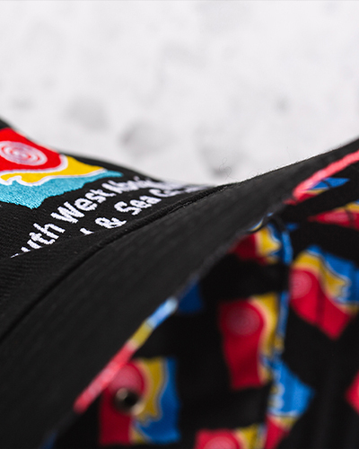 A close-up of a black hat featuring colourful abstract patterns in red, blue, and yellow