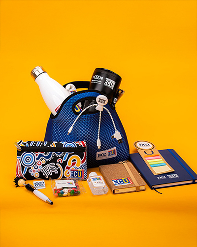 A blue bag filled with ECU-branded items, including a white bottle, mug, keychains, and more