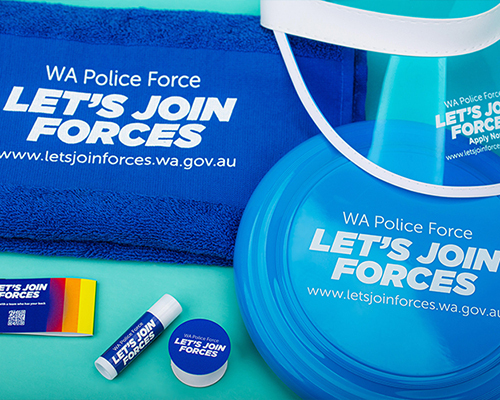 Promotional branded items from wa police force, including a frisbee, face shield, towel, lip balm, and badge
