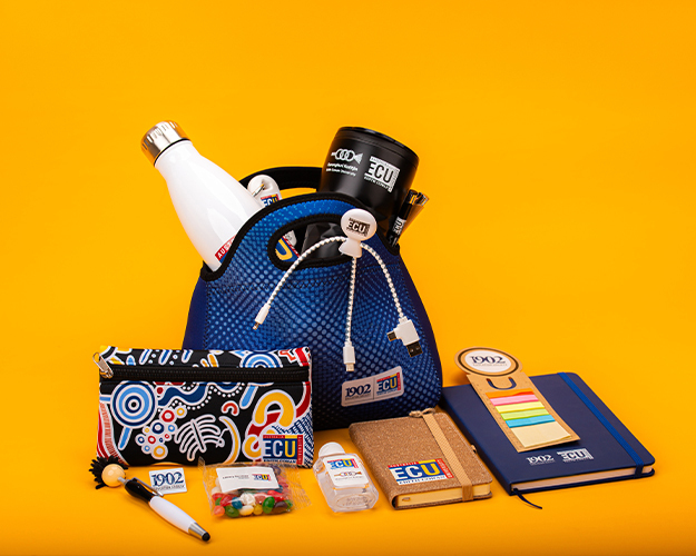 A blue mesh bag filled with branded items like bottles and mugs against a bright orange backdrop