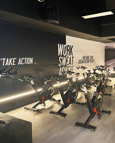A modern indoor cycling studio with sleek stationary bikes lined up