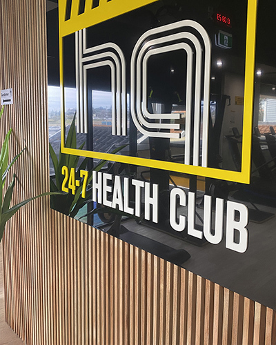 Modern gym entrance with a sign reading 24-7 health club
