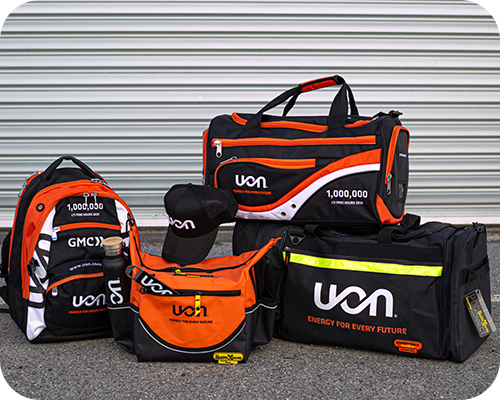 A display of uon-branded sports bags and gear with bold orange, black, and white designs