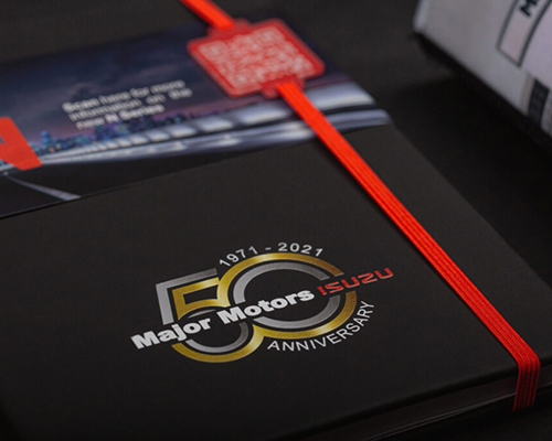 A close-up of a black book with a red ribbon bookmark