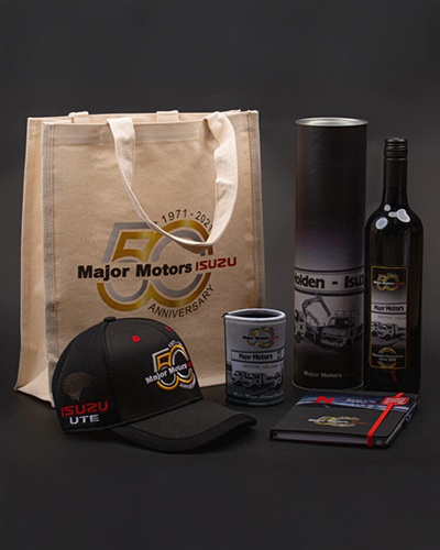 A tote bag next to a hat, a bottle of wine, and assorted items