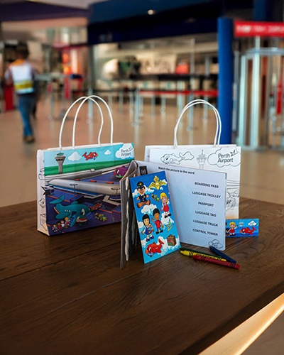 Two colourful paper bags with aviation-themed designs
