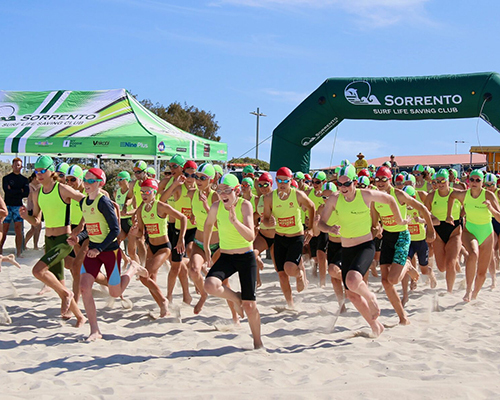 A group of young life savers running along the beach