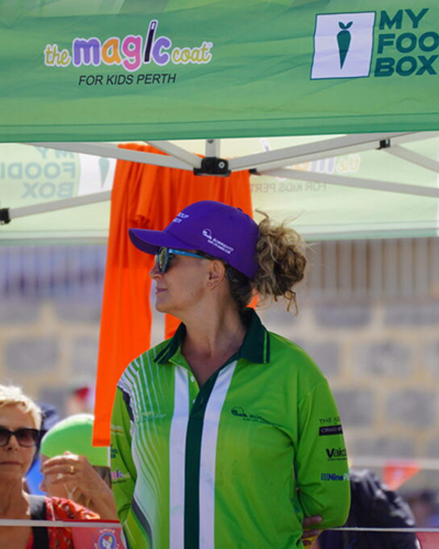 A female life saver in a green shirt and purple cap