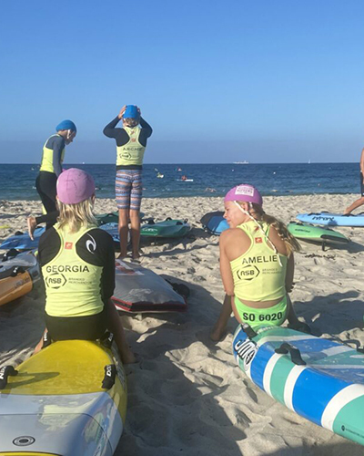 A group of young life savers relaxing on the beach with surfboards