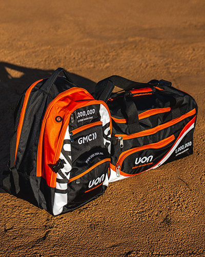 Two sporty bags, one backpack and one duffel, in bright orange, black, and white