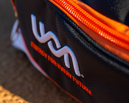 Close-up of a uon-branded black bag with an orange zipper