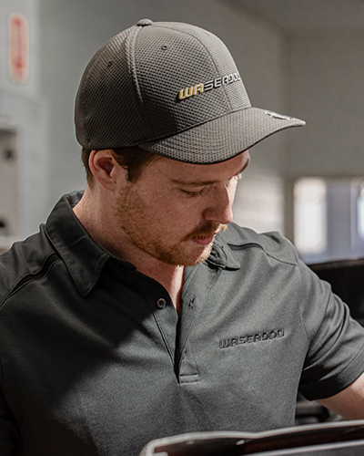 Man wearing black wa seadoo-branded polo shirt and cap