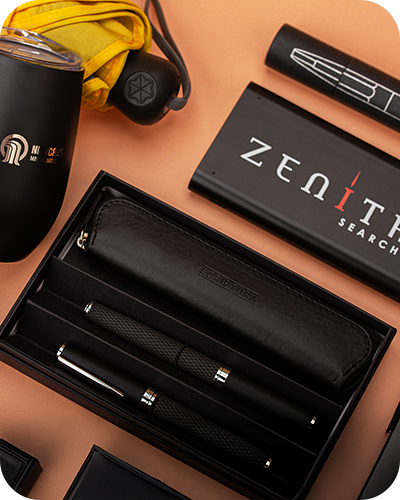 A black pen set with a leather case surrounded by a black mug, yellow umbrella, and a zenith branded box