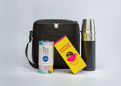 A black bag, a thermos, a pastel tea canister and a bright yellow coffee biscuit box