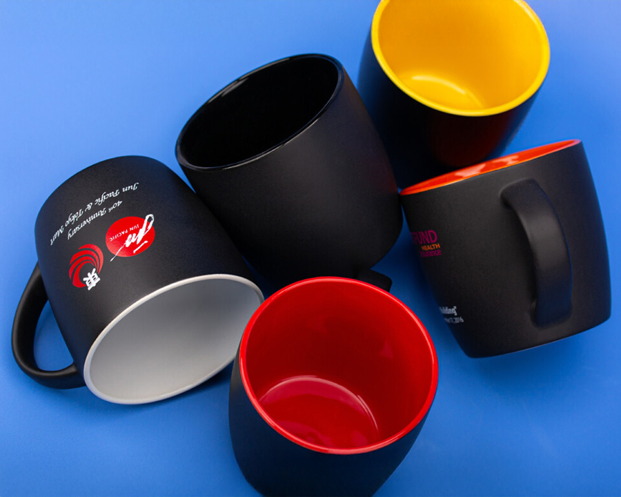 A range of black mugs with colourful inside