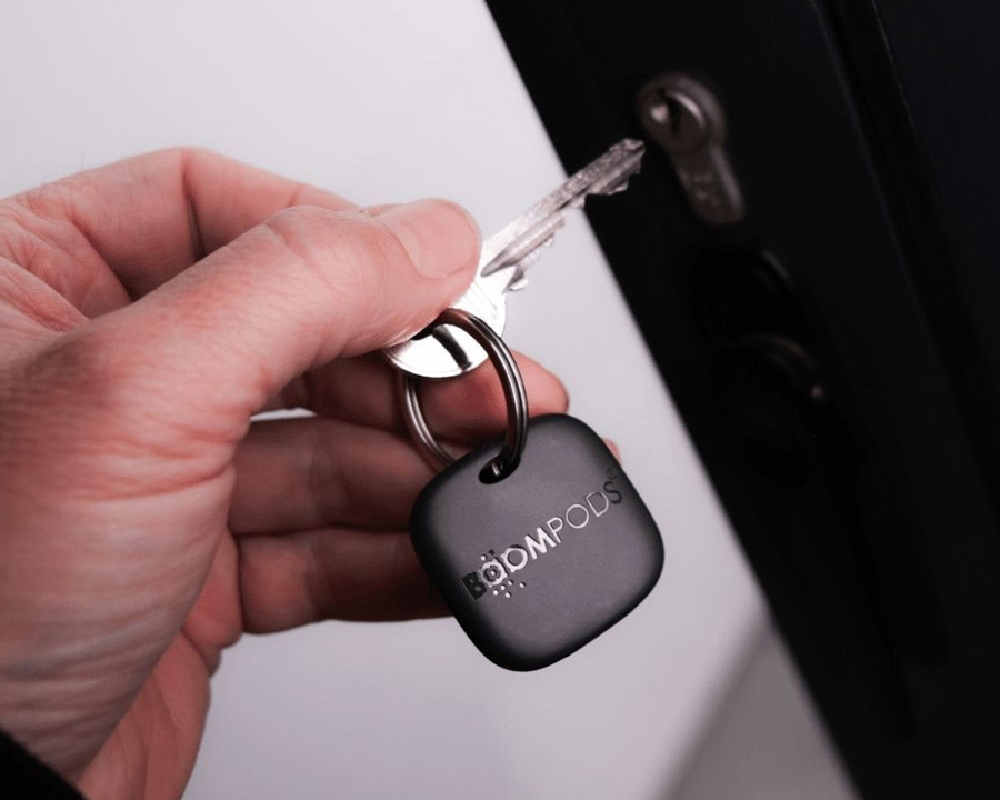Man holding keys with rechargeable tracker attached