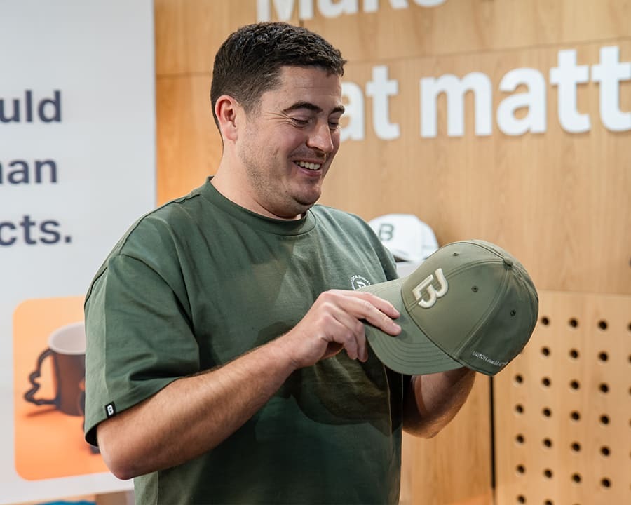 Employee inspecting a Look Brilliant branded hat
