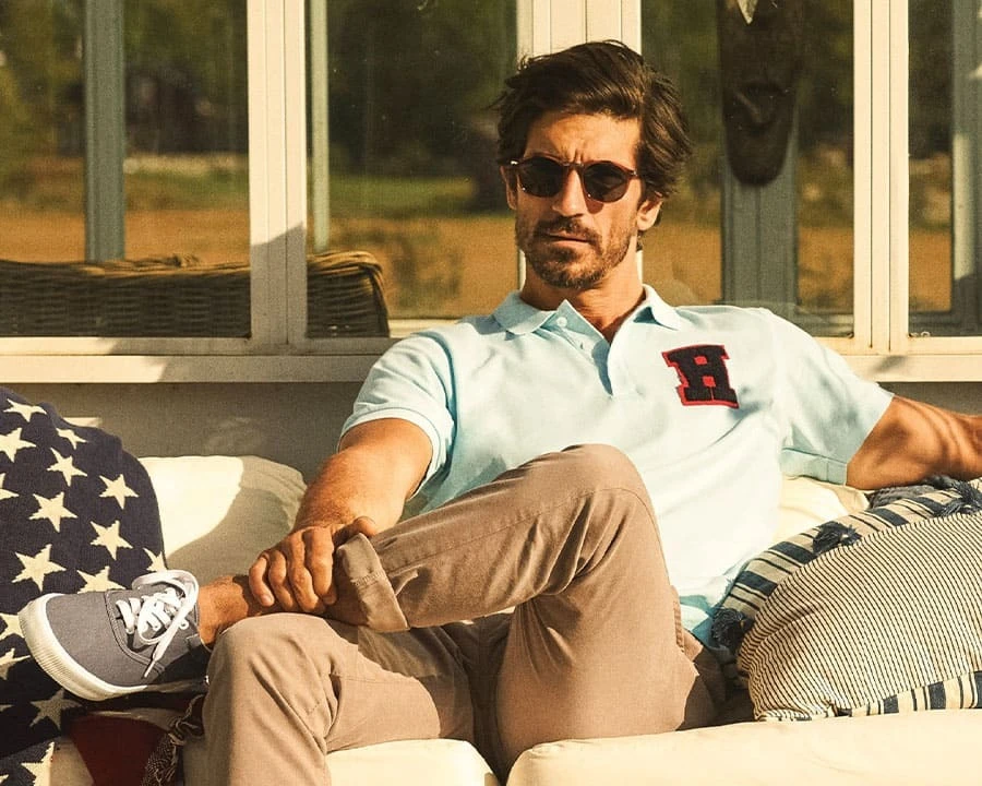 A man wearing a polo shirt sitting outside