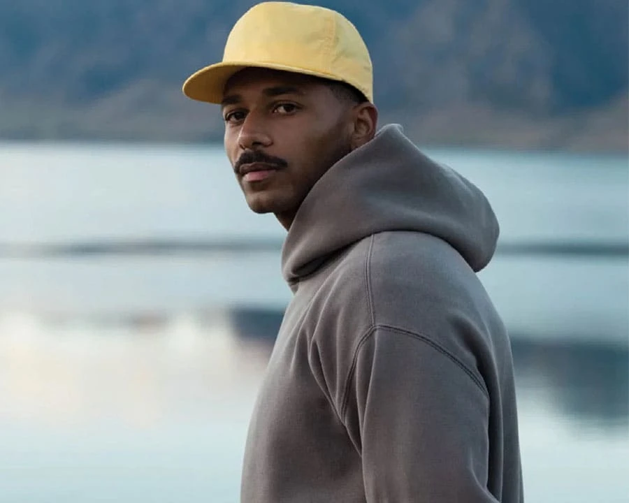 A man wearing AS colour hoodie and cap