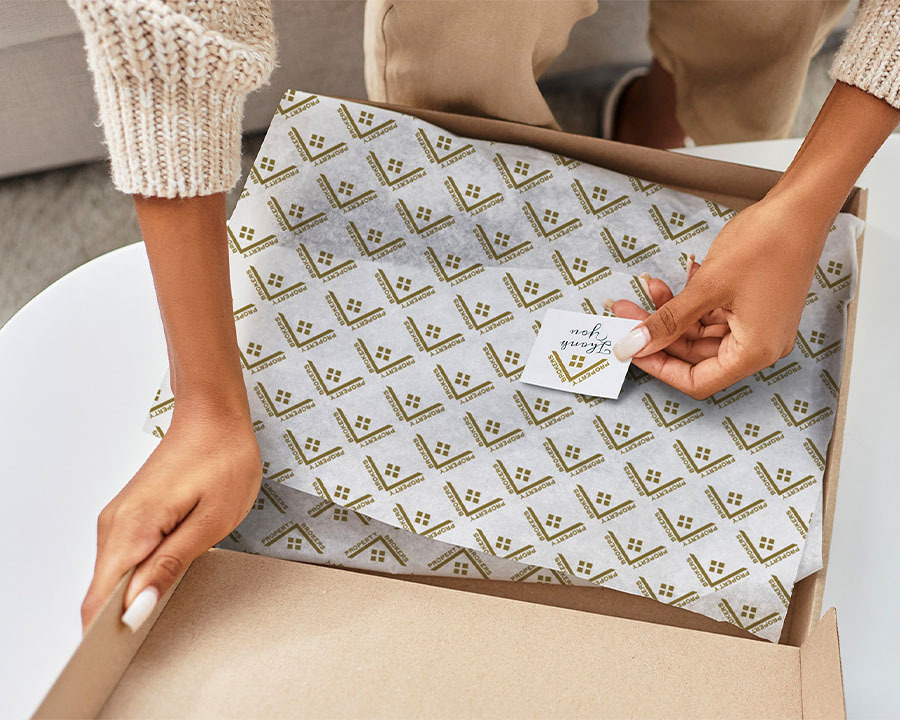 A woman placing a note ontop of gift wrapping paper