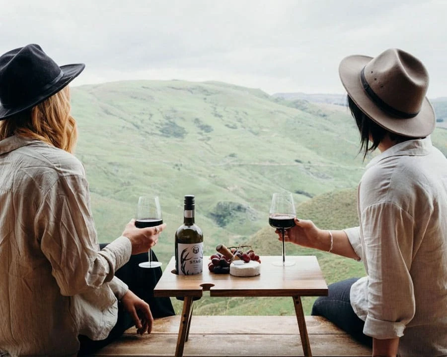 Two people having wine overlooking mountains