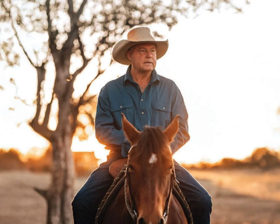 An older man riding a horse