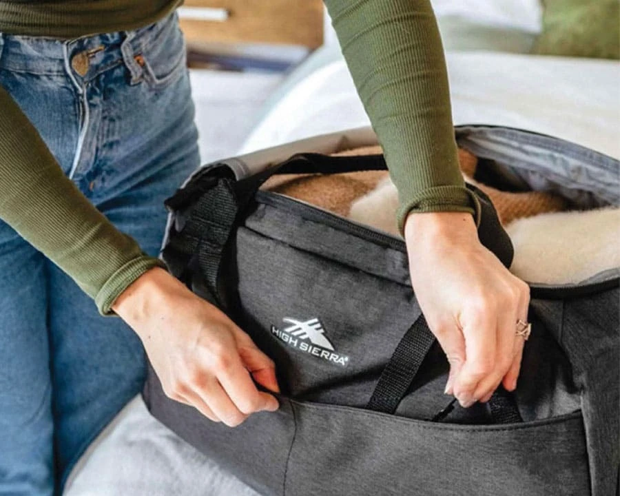 A woman opening the pocket of a bag