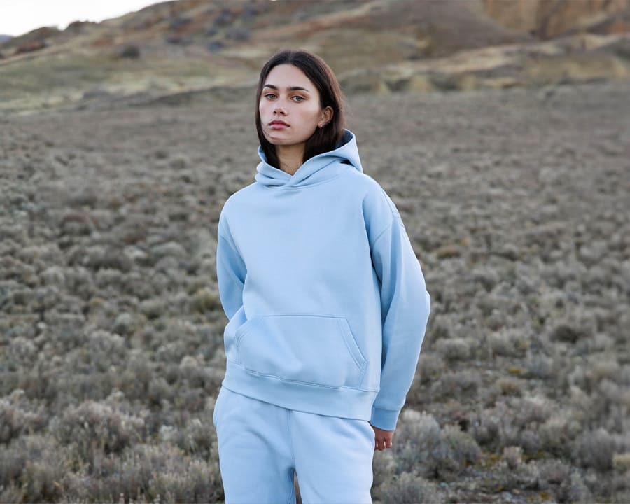 A woman wearing a relaxed AS Colour hoodie
