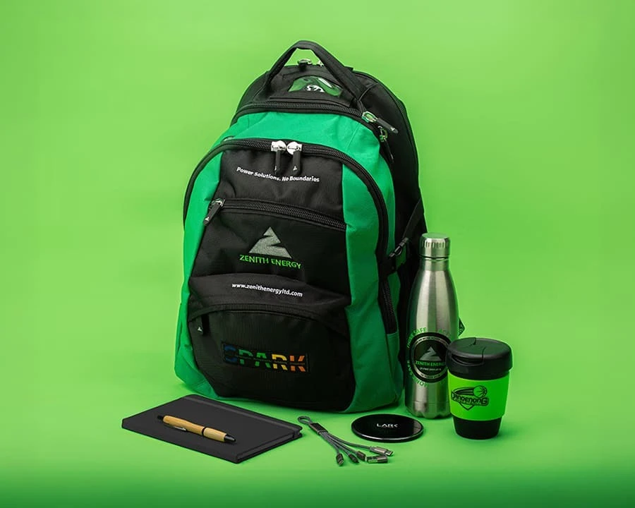 A black and green backpack along with drinkware and stationery