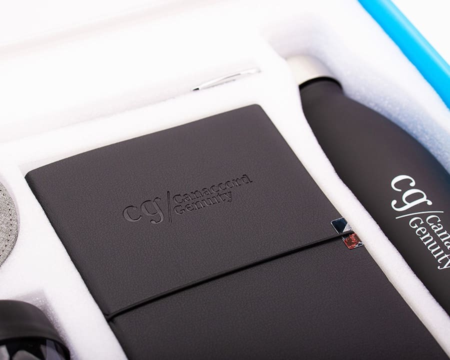 A close-up of a Cannacord Genuity notebook and bottle