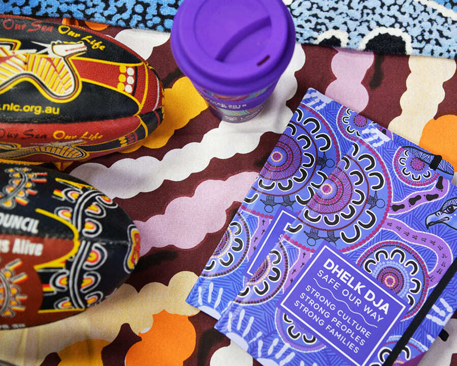 Close-up of a branded notebook, keep cup and football