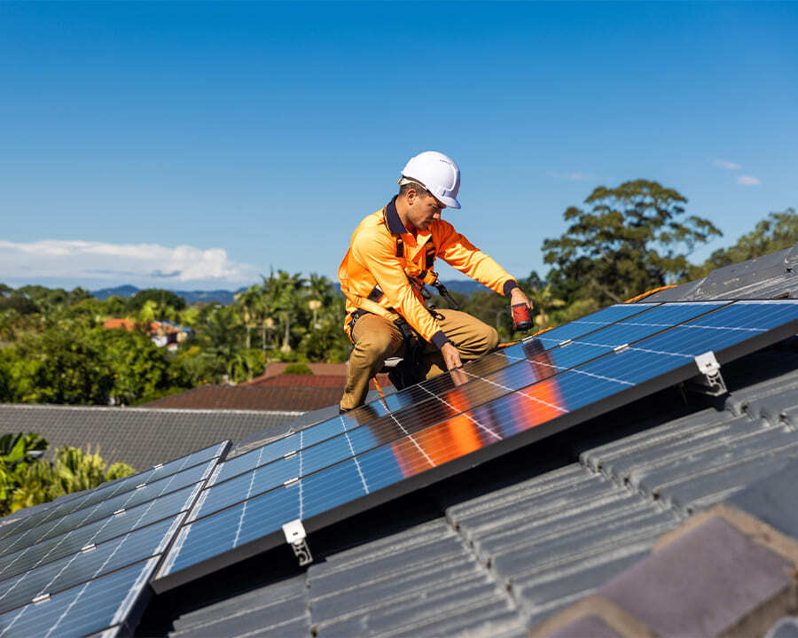 Worker on a roof installing solar panels
