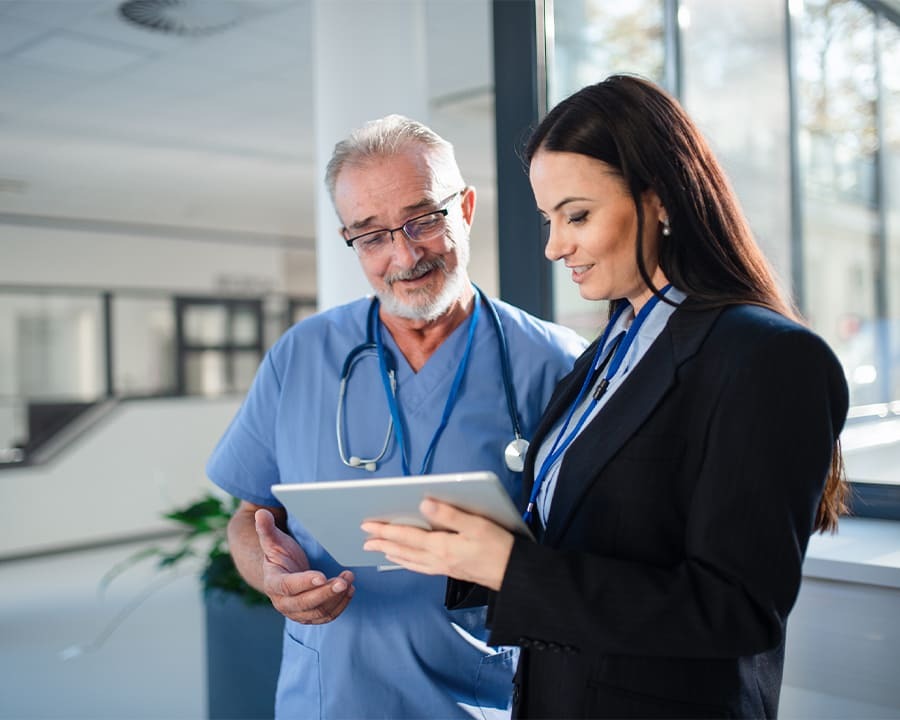 Two health care professionals looking at a tablet