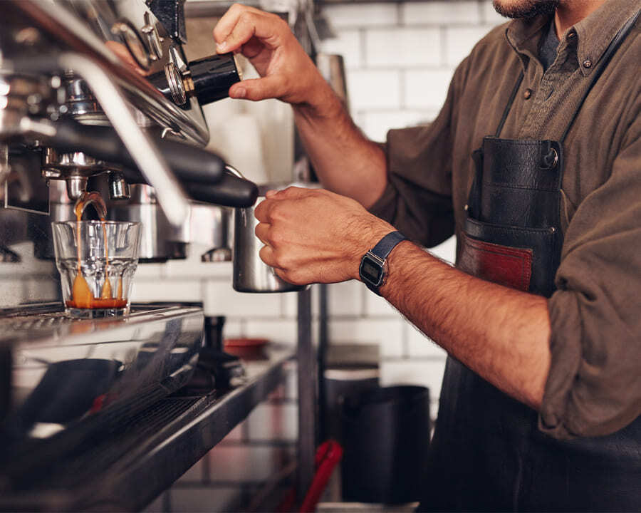Close-up of a barista using a coffee machine