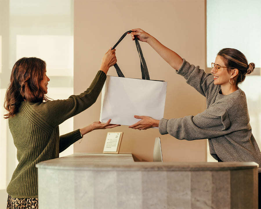 A retail worker handing a bag to a customer
