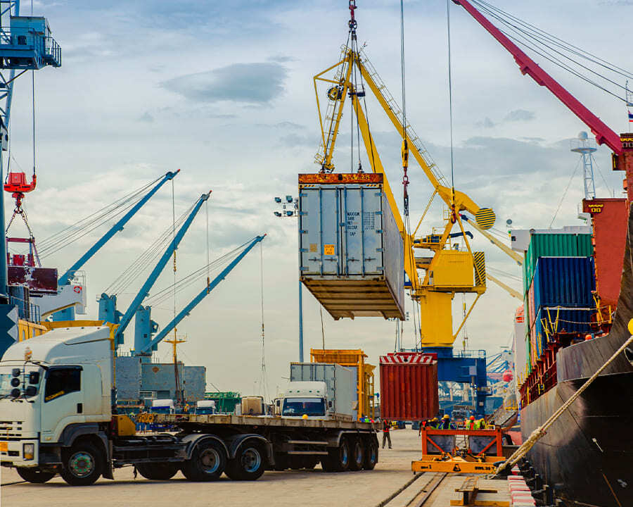 A crane loading a shipping container onto a truck