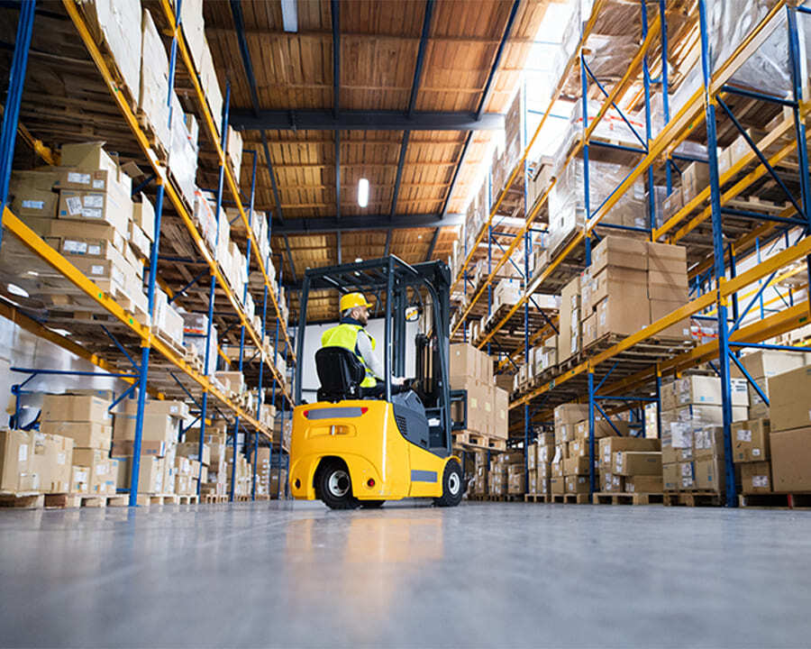 A man using a forklift in a warehouse