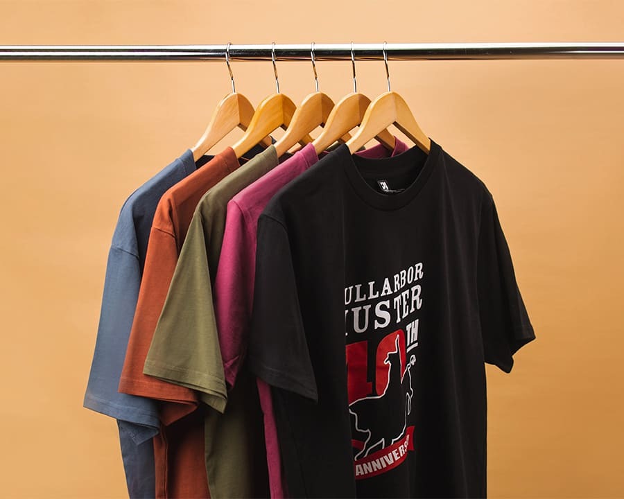 Colourful Nullarbor Muster Club shirts hanging on a rack