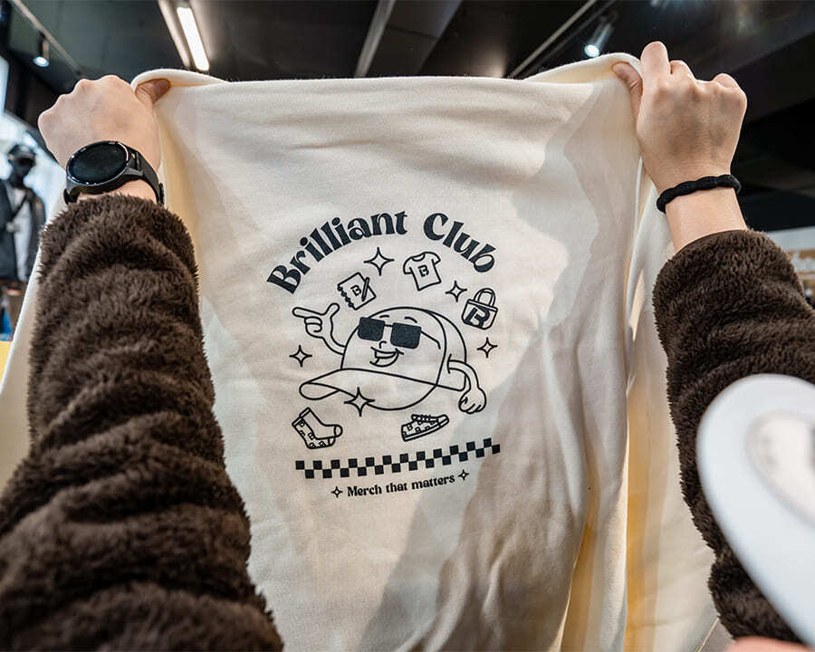 Close-up of a person holding up a Look Brilliant branded jumper