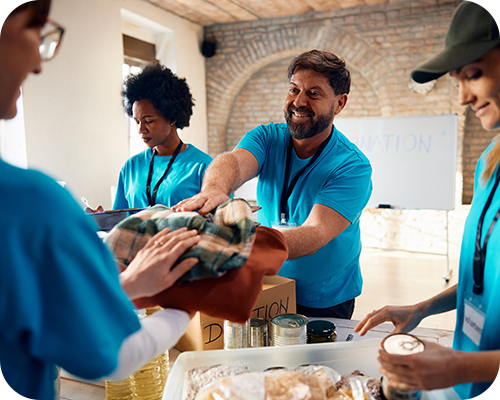 Volunteers in blue shirts happily organise clothing and food donations