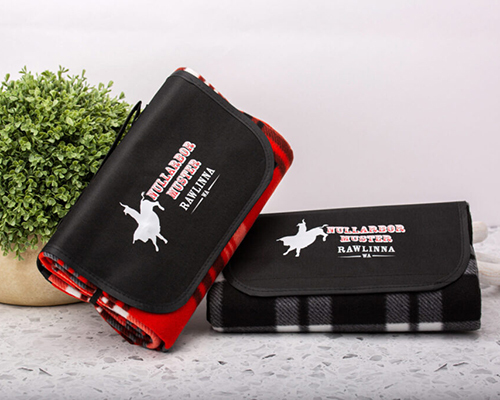 Two black and red picnic blankets featuring a horse design on each
