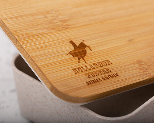 A bamboo cutting board with a logo reading nullarbor hustler, outback australia